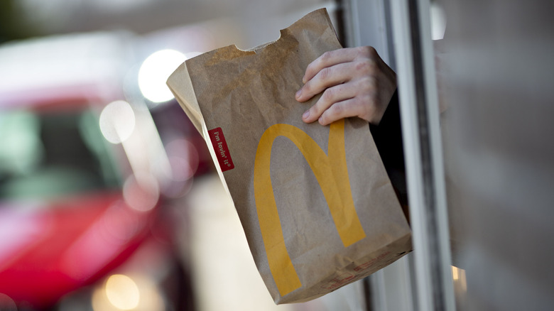 A McDonald's employee hands over an order to a customer