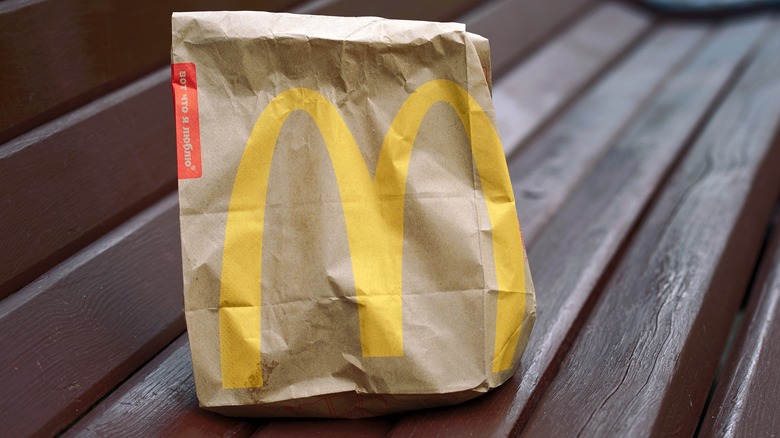 McDonald's bag on wooden bench