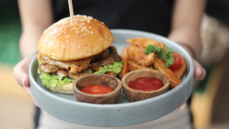 Waitress carrying hamburger and fries