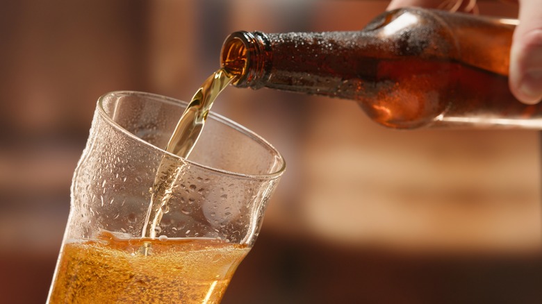 pouring beer bottle into glass