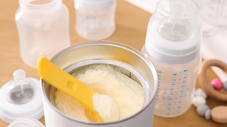 Baby formula with clear bottles and yellow spoon