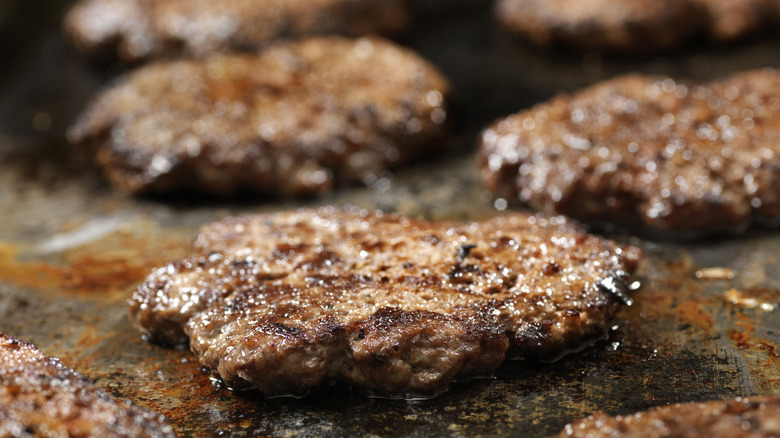 patties cooking on a grill