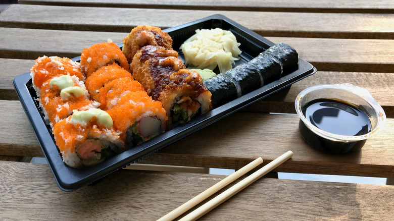 Sushi in a box with chopsticks and soy sauce