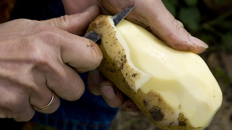 man peeling potato