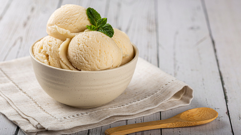 ice cream in bowl with leaf and wooden spoon