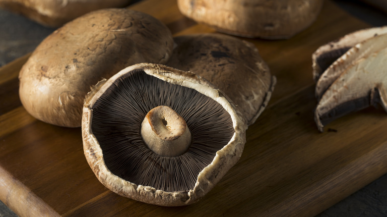 Portabello mushrooms on wooden cutting board