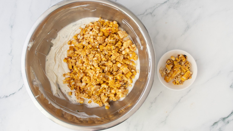Corn in bowl with creamy dip next to small bowl of corn