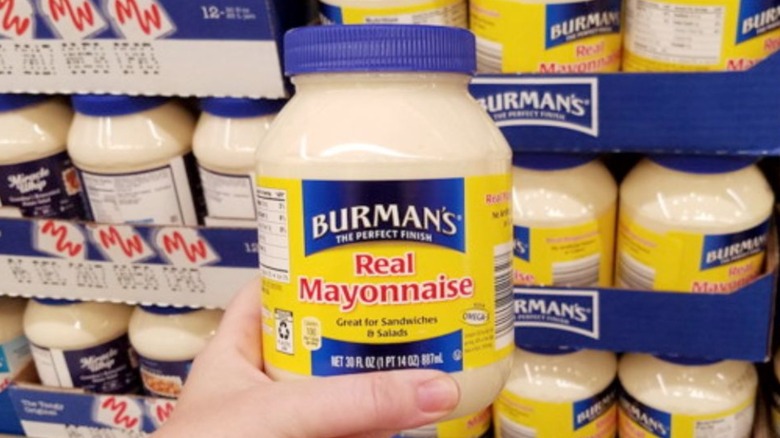 Person holding a jar of Burman's Mayonnaise from Aldi