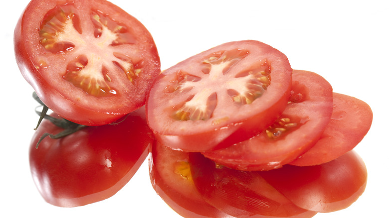 tomato cut into slices on white background