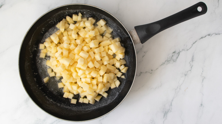 chopped apples in a black frying pan