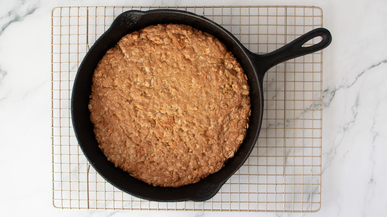 oatmeal cookie in a black frying pan on a wire rack