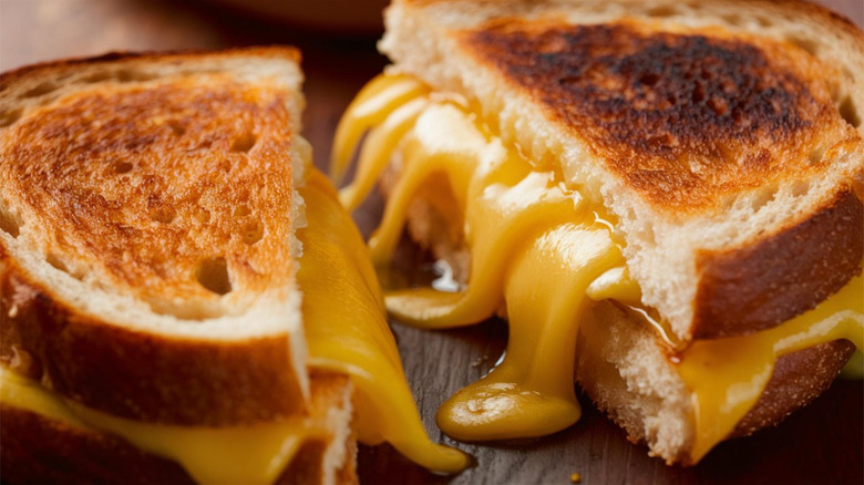 A closeup of a grilled cheese sandwich with gooey cheese oozing out
