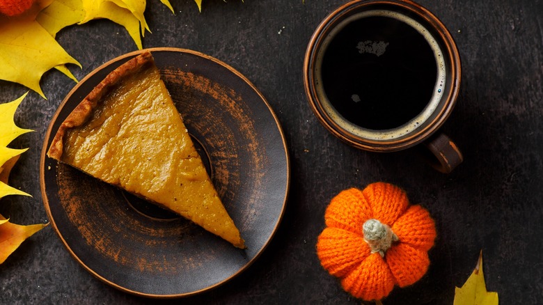 Slice of pumpkin pie with coffee