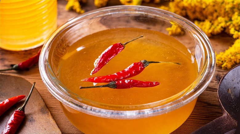 hot honey in a glass bowl with hot peppers
