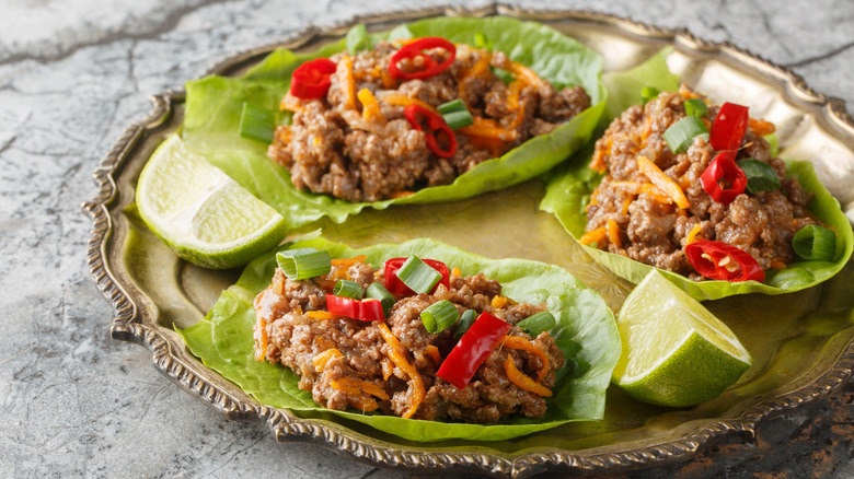 Ground beef lettuce wraps with lime wedges