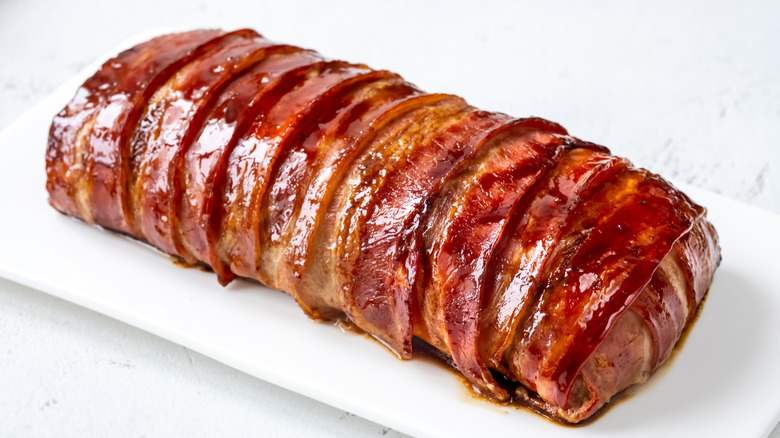 Meatloaf wrapped in bacon on a plate