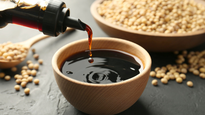 Soy sauce being poured into a wooden bowl