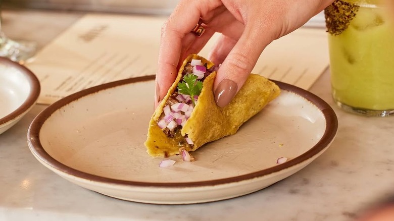 person picks up taco at Alma Fonda Fina