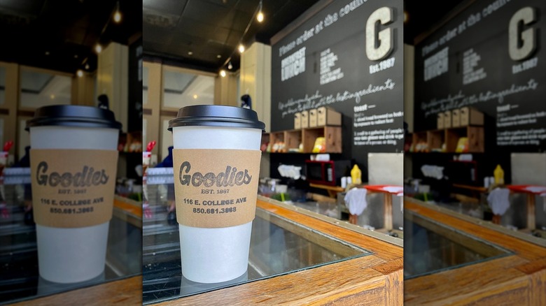 To-go coffee cup with Goodies sleeve on restaurant counter