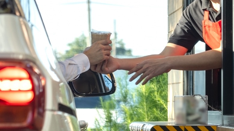 car receiving iced coffee at drive thru