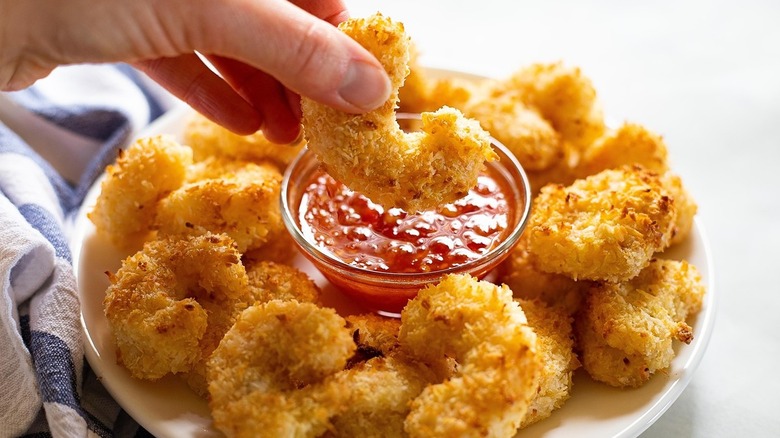 hand dipping coconut shrimp