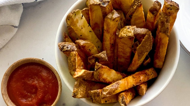 Air fryer French fries in a cup with dipping sauce