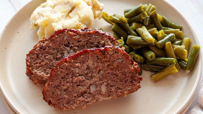 meatloaf on plate with mashed potatoes and green beans