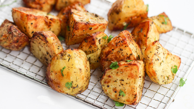 Close up of air fried potatoes sitting on a wire rack