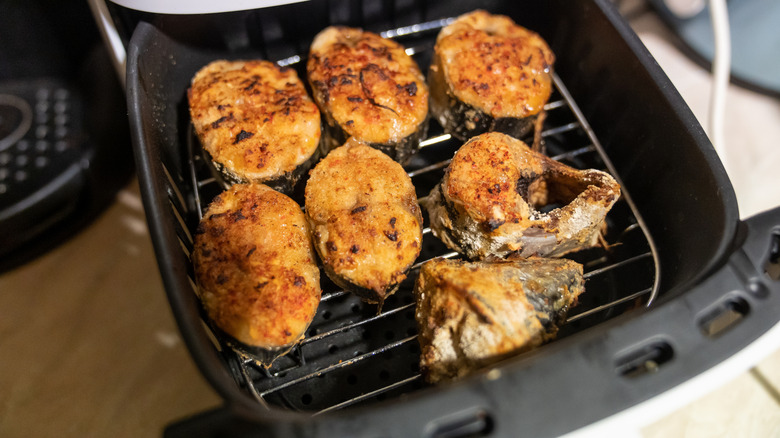 Pieces of fried fish inside an air fryer basket