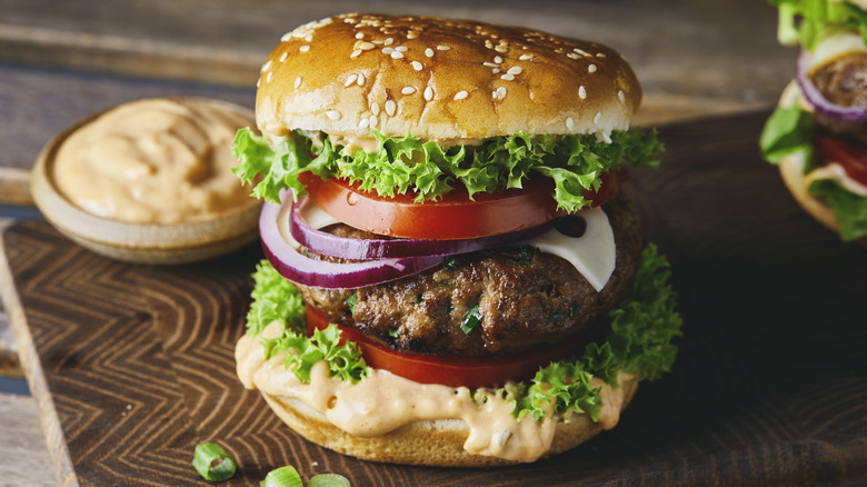 saucy burgers on cutting board