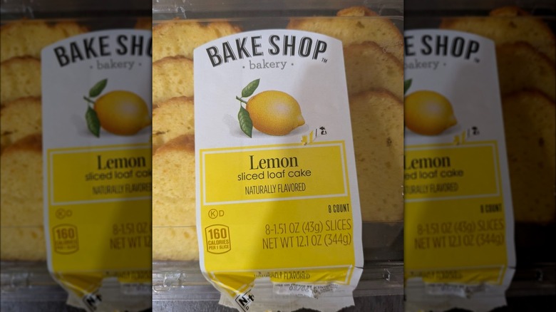 A clear plastic box full of lemon bread slices with a big Bake Shop logo on top.