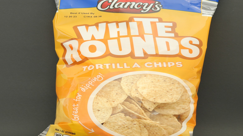 A yellow and blue bag of Clancy's White Rounds tortilla chips.