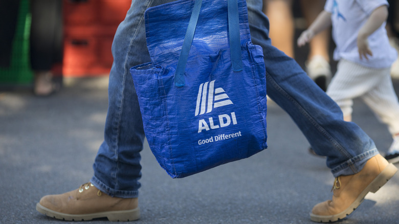 Person walking with Aldi tote bag