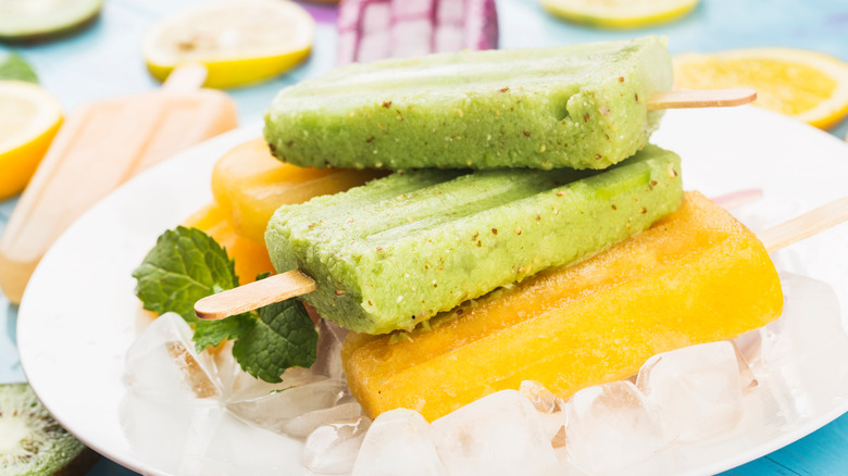 A plate of yellow and green popsicles on a plate