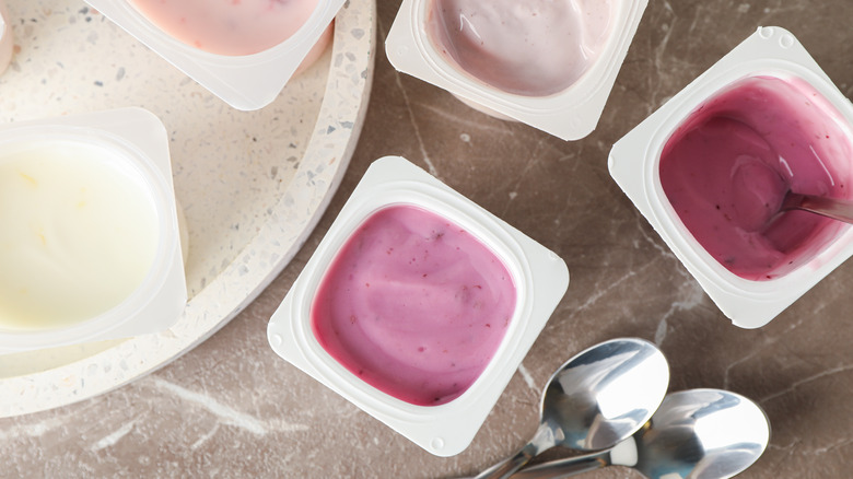 Colorful yogurt cups next to spoons