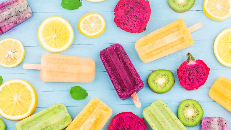 Frozen popsicles and fruit on a picnic table