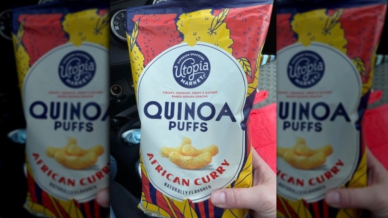 A hand holding the Aldi quinoa puffs