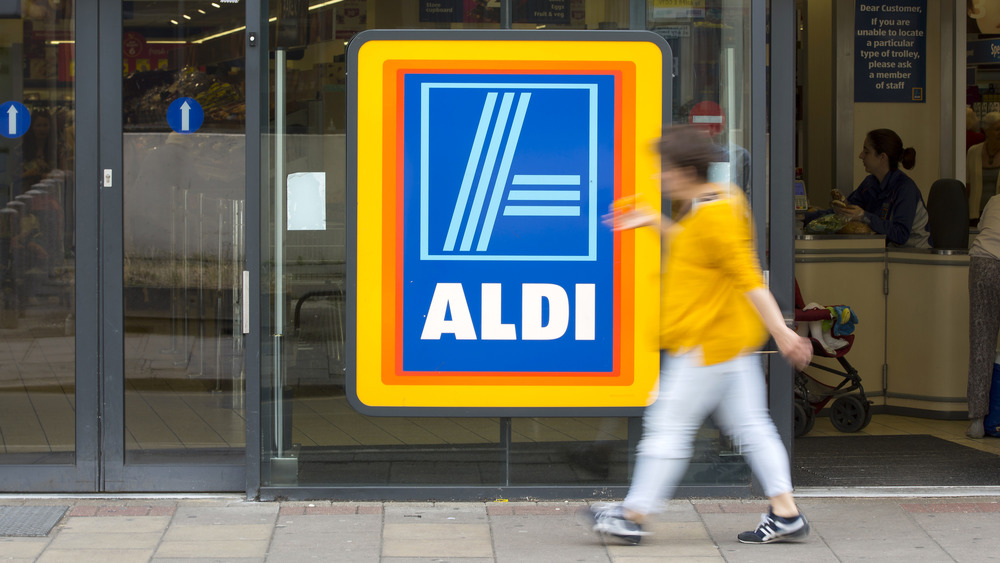 Aldi sign with person in front of it