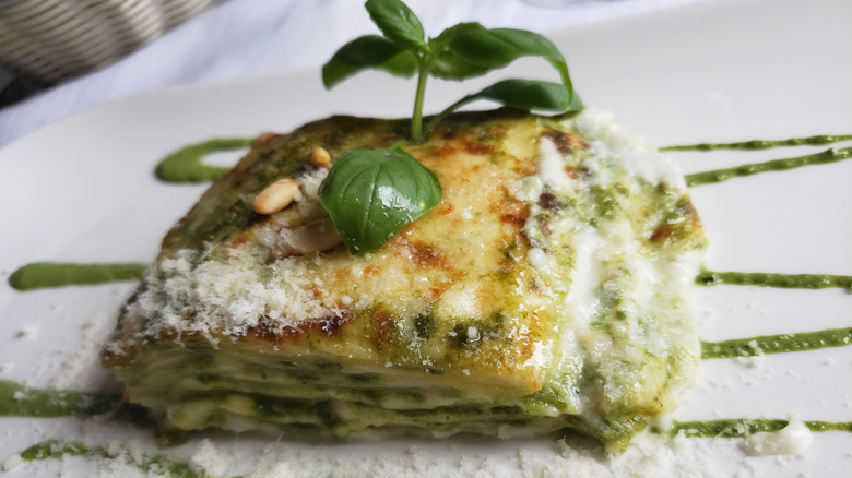 Pesto lasagna topped with basil and grated parmesan