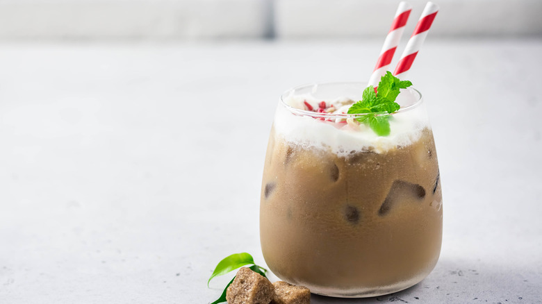 Holiday themed drink in glass with striped straws