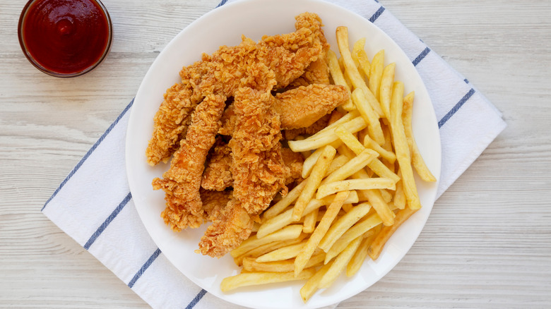 chicken strips plated with fries
