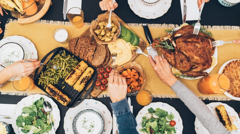 hands reaching over Thanksgiving table