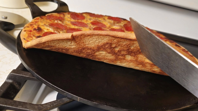 Pizza lifted to show crust on pan