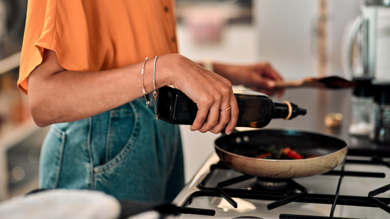 Woman cooking with pan and oil