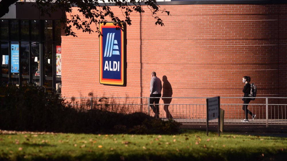 Two people walking into Aldi