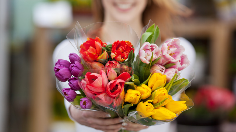 woman offering bouquets of flowers