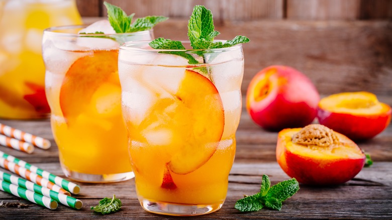 Glasses of cold peach beverages on table