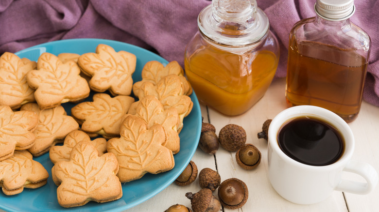 A plate of maple leaf sandwich cookies and a cup of coffee