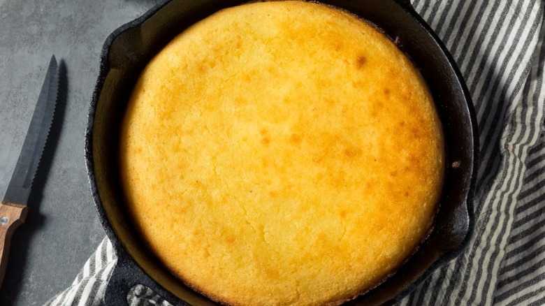 Skillet cornbread on striped linen atop a kitchen counter