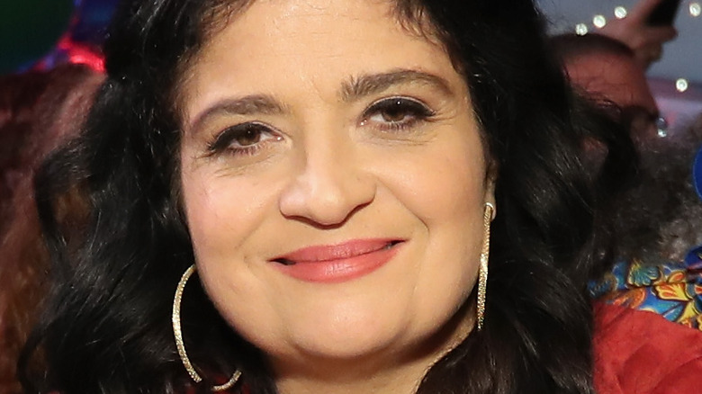 Alex Guarnaschelli wearing a red jacket and smiling